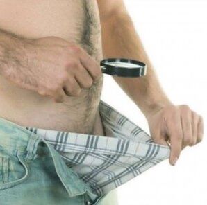 一个男人低头看自己的裤子，想用凝胶增大他的阴茎